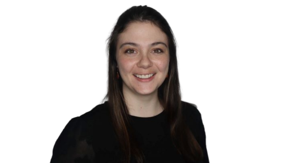 Professional headshot of a smiling woman with long dark hair, wearing a black top against a light background